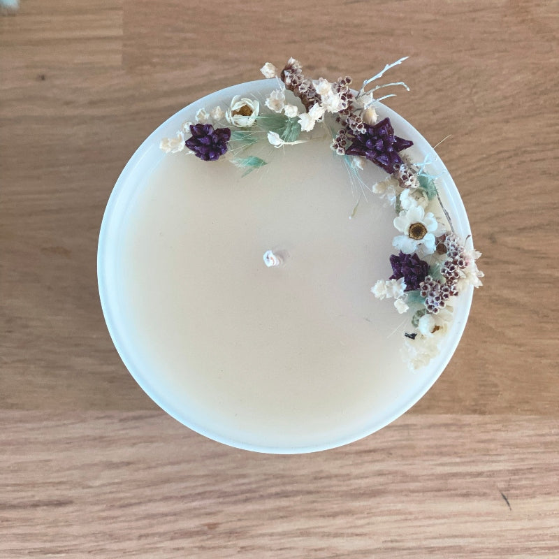 bougie fleurie decoree de petites fleurs sechees dans les tons blanc bleu et violet