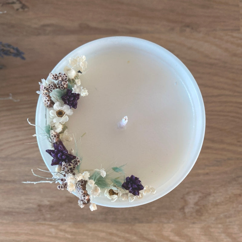 bougie fleurie decoree de petites fleurs sechees dans les tons blanc bleu et violet