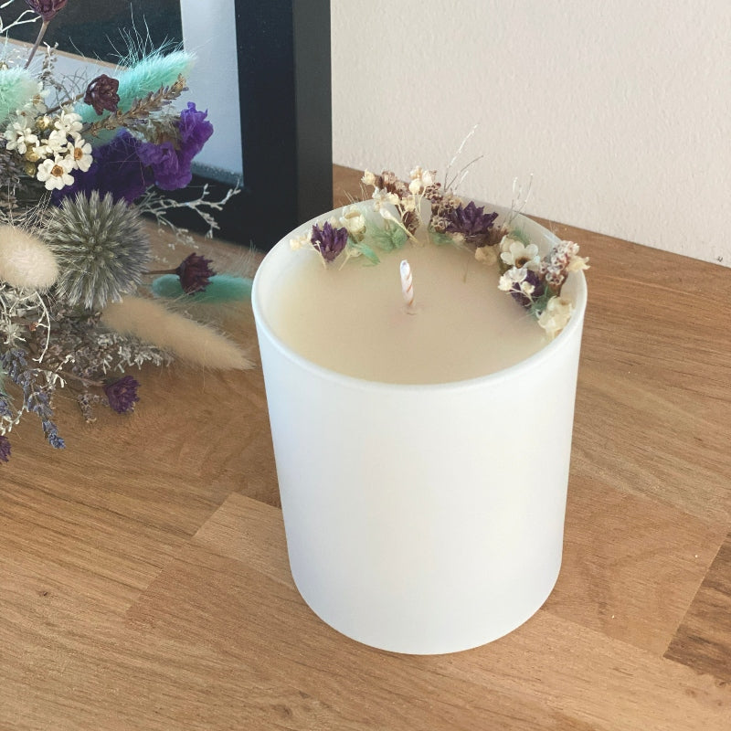 bougie fleurie decoree de petites fleurs sechees dans les tons blanc bleu et violet