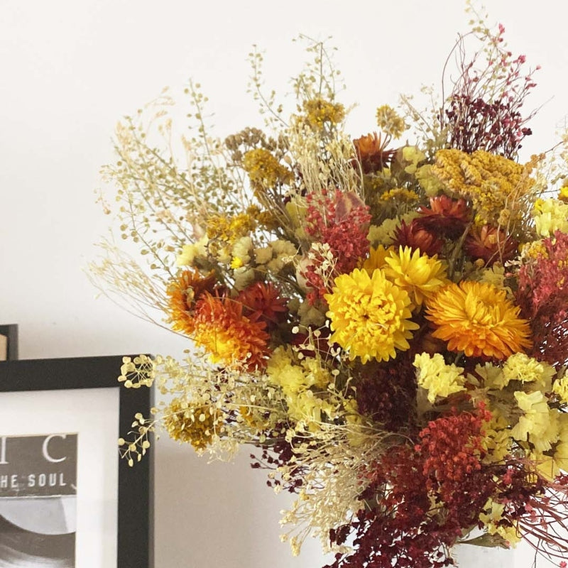 bouquet de fleurs séchées dans les tons jaune orange et bordeaux